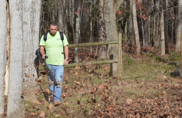 man cleaning up leaves with backpack blower